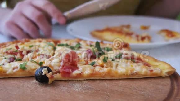 女孩的手切一片披萨把它放在咖啡馆的盘子里多利射击视频的预览图