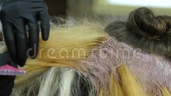 理发师为一个在美容院的青少年做发型和染色染的头发慢动作视频的预览图