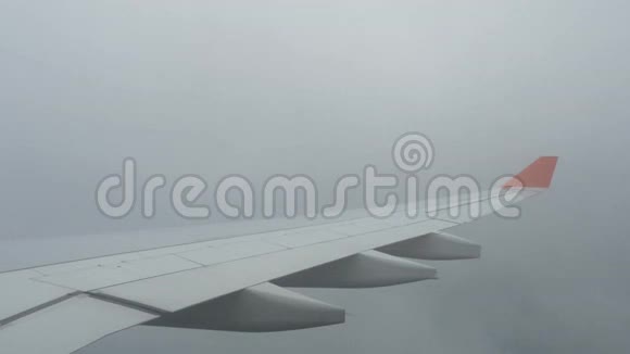 透过飞机窗户看到的云和天空飞行在云层之上的飞机的机翼人们看着视频的预览图