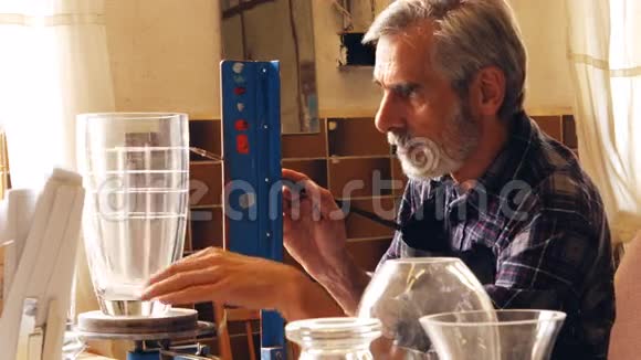 吹玻璃的人在玻璃花瓶上工作视频的预览图