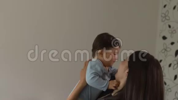 母亲抱着玩她的小儿子和他说话亚洲混血儿男孩穿着蓝色体恤视频的预览图