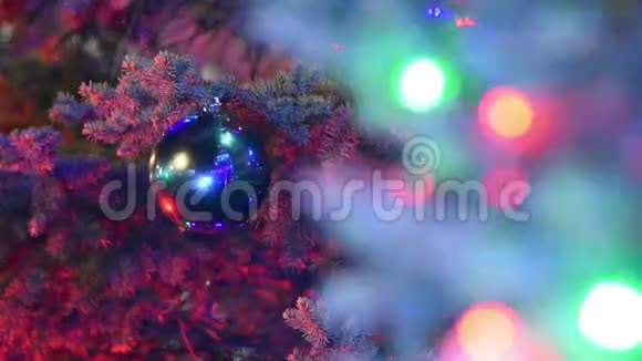 巨大的圣诞球挂在圣诞树的前景模糊的灯光花环上视频的预览图