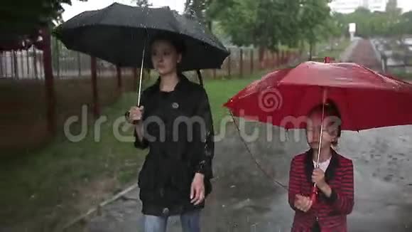 母女俩在大雨中走在街上视频的预览图