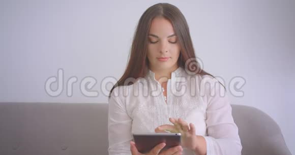 用平板电脑拍摄白种人年轻女商人戴眼镜的特写肖像并用绿色的彩色屏幕拍摄视频的预览图