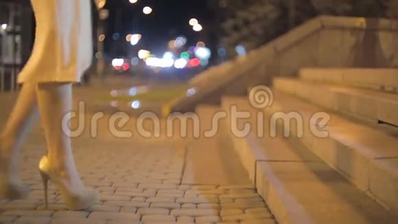 晚上穿高跟鞋走在石阶上的女人特写镜头视频的预览图