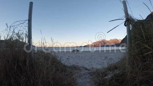 小小径和大门前面的白色海滩沙子与海洋和山视频的预览图