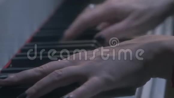 带戒指的女性手臂黑色指甲油弹钢琴的红弦手镯视频的预览图