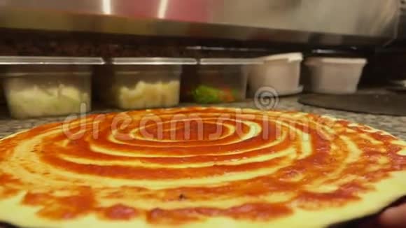比萨饼面团上抹了番茄酱视频的预览图