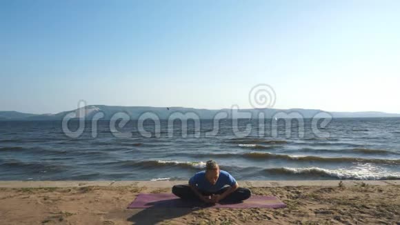年轻人在度假期间在海滩上练习瑜伽视频的预览图