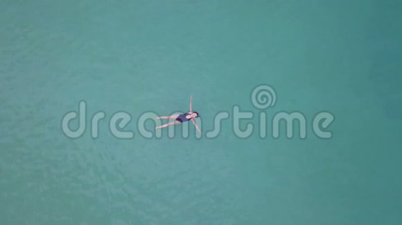漂浮在海上的亚洲女孩鸟瞰图视频的预览图