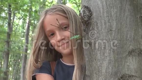森林中的孩子大自然中的孩子冒险户外的女孩树后视频的预览图