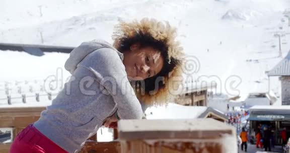 滑雪场上靠在栏杆上的微笑女人视频的预览图