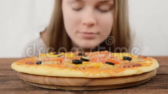 一个女人嗅披萨的特写镜头视频的预览图