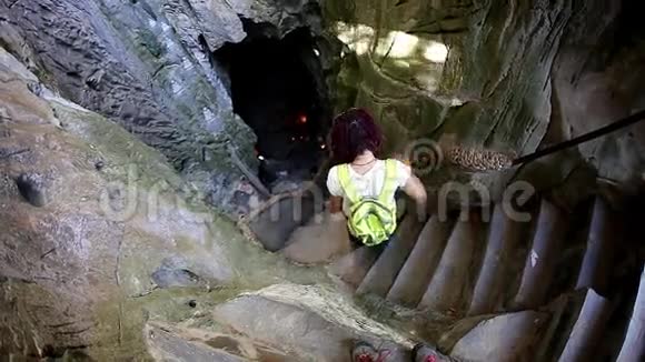 慢动作女孩看着冰冻洞穴中的瀑布视频的预览图