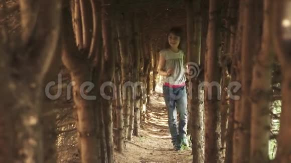 小女孩走过树洞神秘而神奇的森林里的孩子慢动作视频的预览图