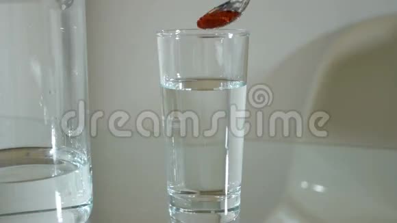 在玻璃杯中加入一勺辣椒粉加水搅拌视频的预览图