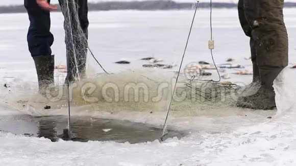 渔民把鱼从冰冻池塘的洞里拉出来视频的预览图