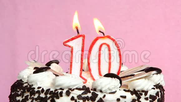 十周年庆典蛋糕和蜡烛放在粉色背景上视频的预览图