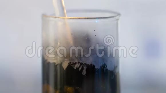 从烧瓶中取出黑色混合物黑色背景玻璃烧瓶视频的预览图