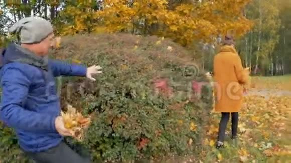 父亲在秋天公园和女儿玩然而他们笑了笑爸爸把树叶扔在一个视频的预览图