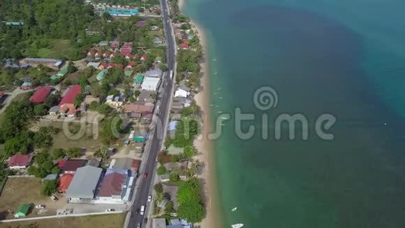 在靠近白沙滩和海滨的道路上沿公路行驶的住宿和交通的航空视野视频的预览图