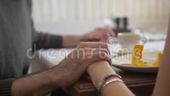 手牵着年轻夫妇在咖啡厅享受甜点视频的预览图