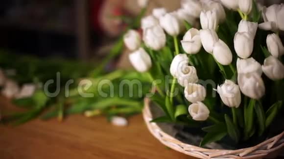 篮子里的白色郁金香在背景中一个工作花店是可见的视频的预览图