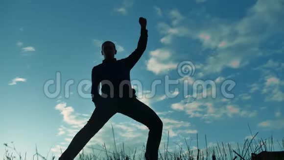 一个男人在日落时滑稽地跳舞的剪影有趣的男人笑跳舞娱乐疯狂的快乐视频的预览图