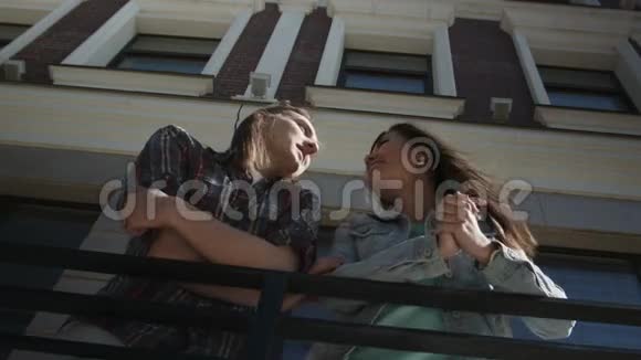 漂亮的女孩和留着长发的男孩站在大楼附近视频的预览图