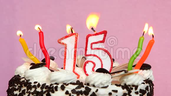十五周年纪念蛋糕和蜡烛放在粉色背景上视频的预览图