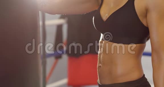 女拳击手的手臂在拳击袋上的肖像视频的预览图