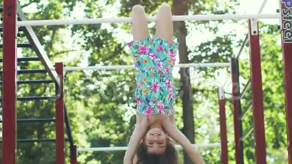 小有趣的女孩倒挂在水平杆上视频的预览图