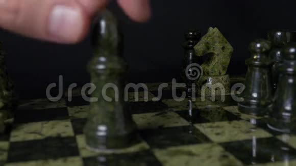 棋中黑象打败白马黑色背景下棋子的细节象棋比赛特写视图视频的预览图