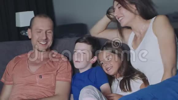 一家人在晚上看电视视频的预览图