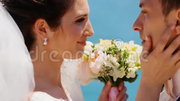 结婚后在大海的背景下拥抱着婚礼的花束视频的预览图