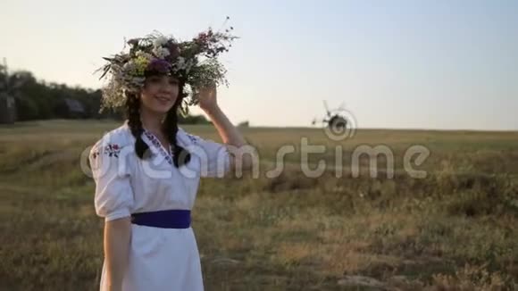 在草地上散步的女孩穿着花圈在大自然的夕阳下穿着民族服装视频的预览图