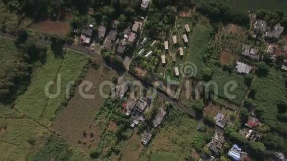 从空中俯瞰农村地区农田街道房屋屋顶森林视频的预览图