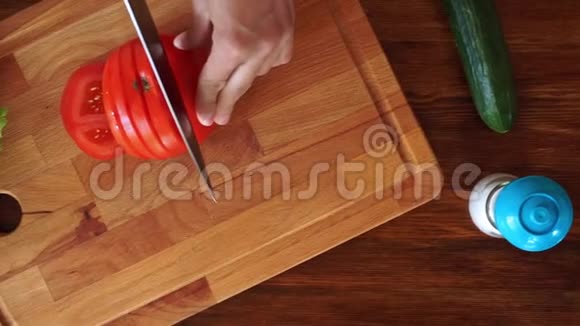 女孩在木板上切红成熟番茄俯视高清视频视频的预览图