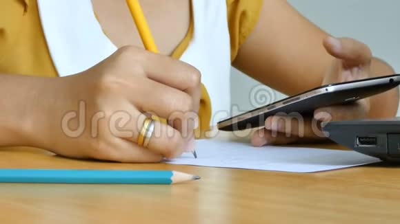 使用手机智能手机和铅笔书写的女性手在纸上隐喻在线应用和商业营销中的选择焦点视频的预览图