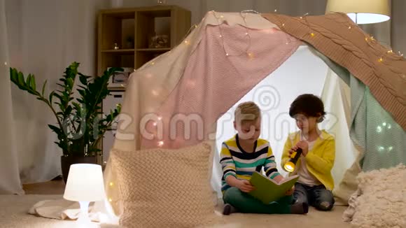 快乐的男孩在家孩子帐篷里看书视频的预览图