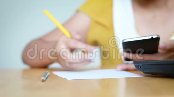 使用手机智能手机和铅笔书写的女性手在纸上隐喻在线应用和商业营销中的选择焦点视频的预览图