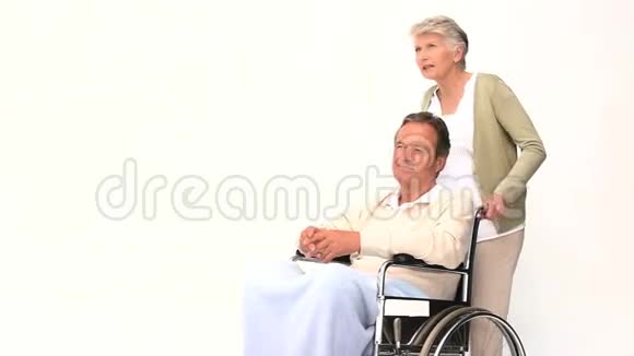 一个坐在轮椅上和妻子说话的男人视频的预览图