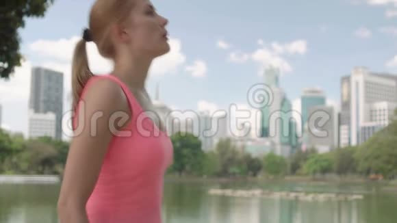 美丽的年轻女子在公园慢跑适合女性运动健身训练休息一下视频的预览图