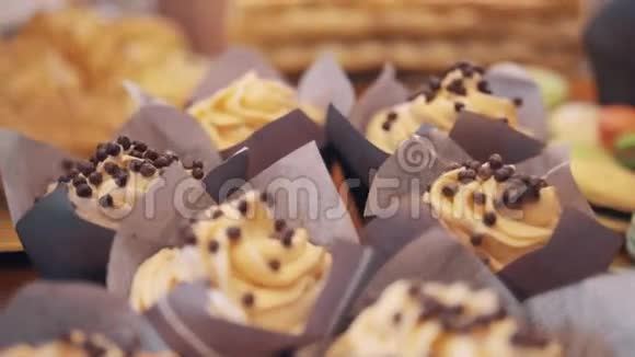 巧克力泡芙滴在面包店小蛋糕上的奶油漩涡上视频的预览图