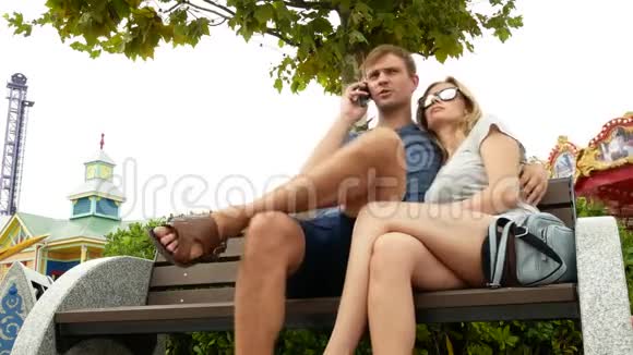 幸福的家庭坐在游乐园的长凳上玩得开心4k复制空间生活方式视频的预览图