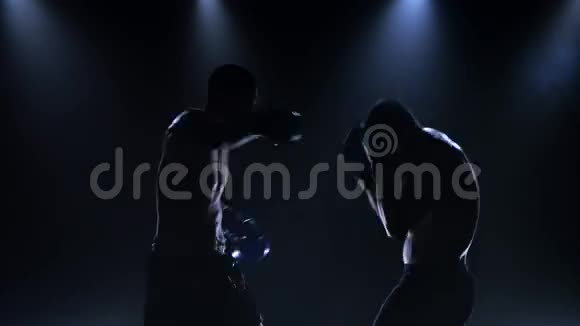 两个拳击手在黑暗的背景下在演播室里打架视频的预览图