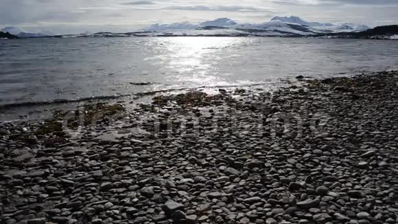 美丽的日出覆盖了北极圈内巨大的雪山蓝天和平静的海浪视频的预览图