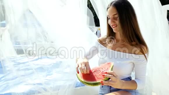 美丽性感的女人女孩在海滩上吃西瓜视频的预览图