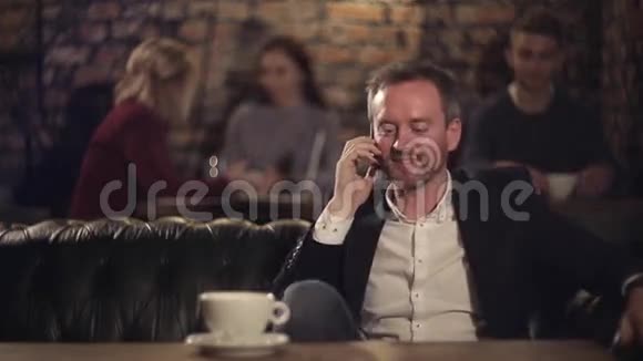 快乐的男人在咖啡馆里用智能手机聊天喝咖啡视频的预览图