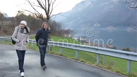 美丽的一对夫妇在阿尔卑斯山的背景上行走视频的预览图